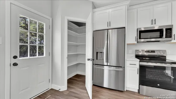a kitchen with kitchen island white cabinets and refrigerator