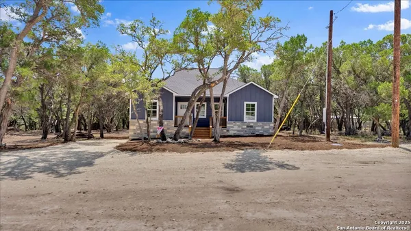 a view of a house with a yard and tree s