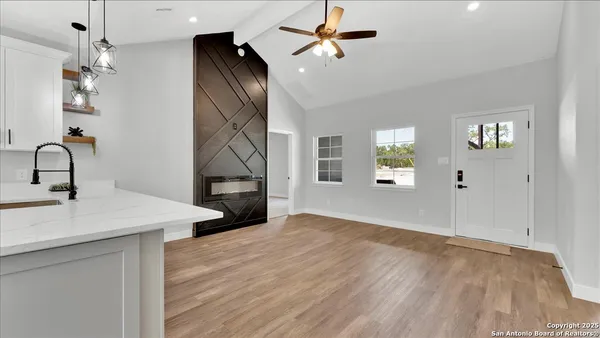 a view of an empty room with window and wooden floor