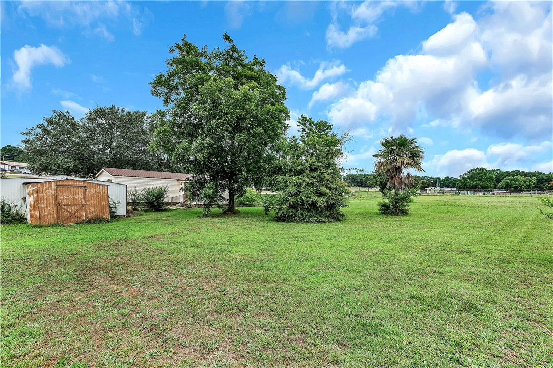 1004 Wiles Road Anderson, SC 29625 - Photo 25 of 26 A spacious, verdant yard with mature trees and a humble shed offers ample outdoor potential.