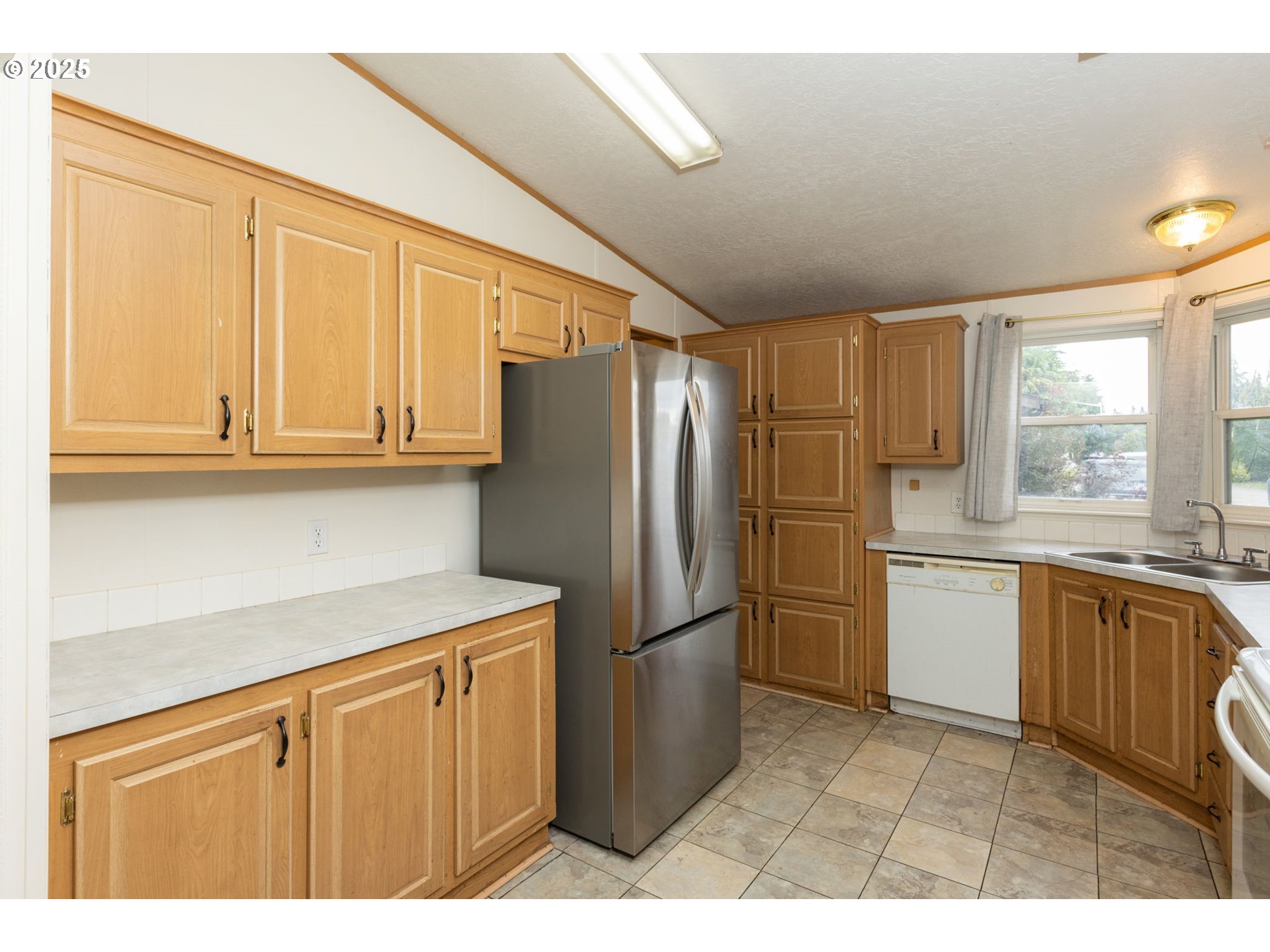 1655 South Elm Street Canby, OR 97013 - Photo 12 of 32 a kitchen with stainless steel appliances granite countertop a refrigerator a sink dishwasher a stove with wooden cabinets