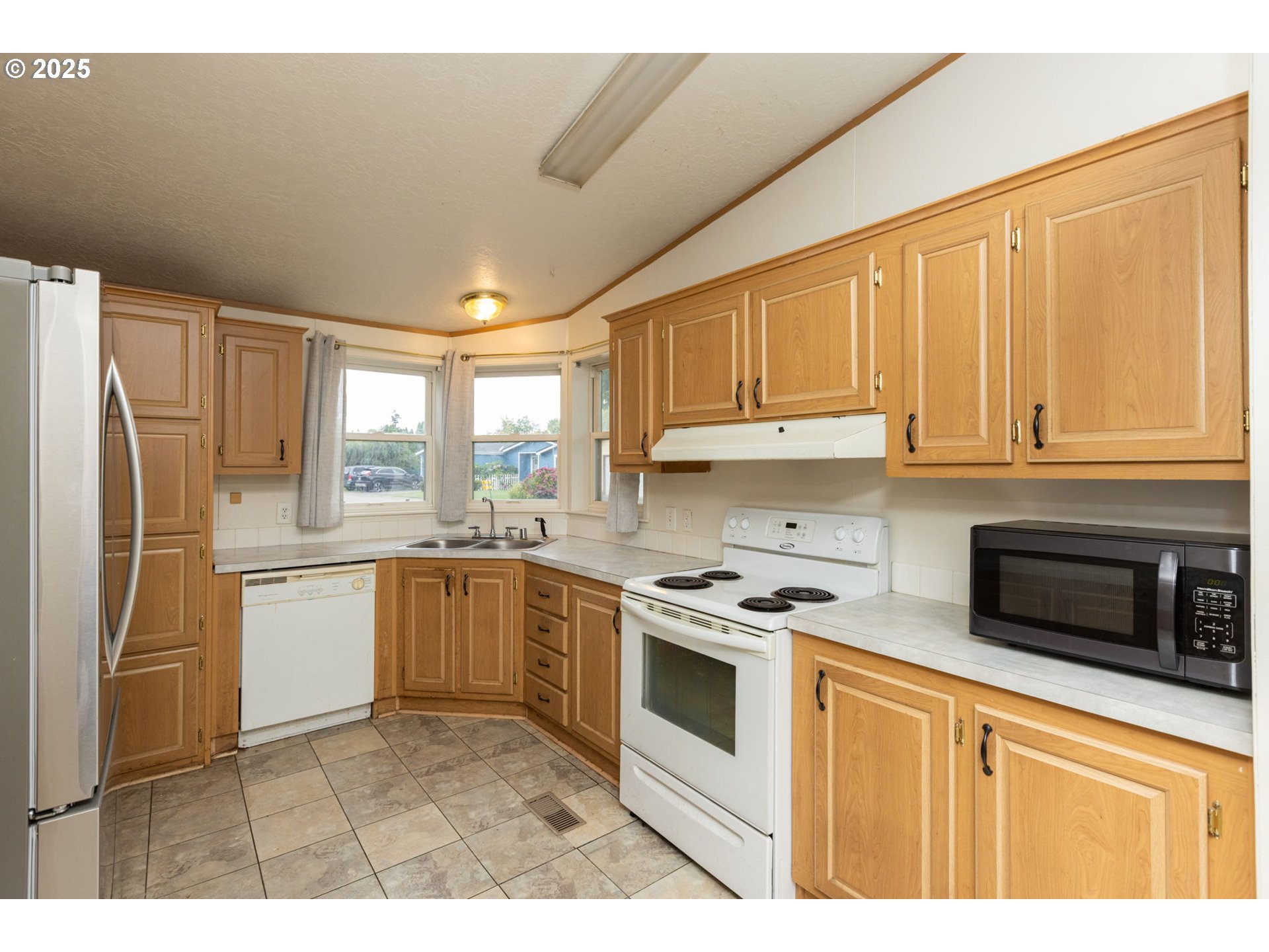 1655 South Elm Street Canby, OR 97013 - Photo 10 of 32 a kitchen with a stove a sink and a refrigerator