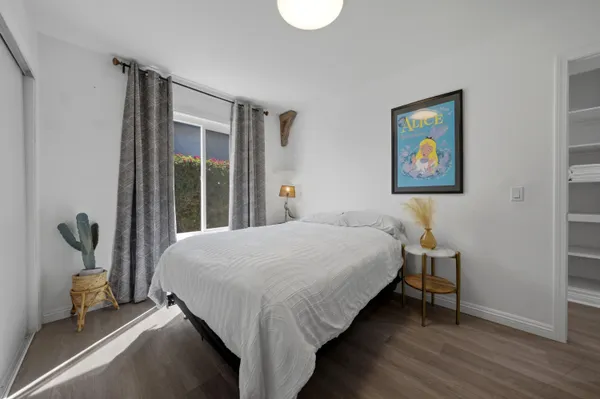 a bedroom with a bed and a painting on the wall