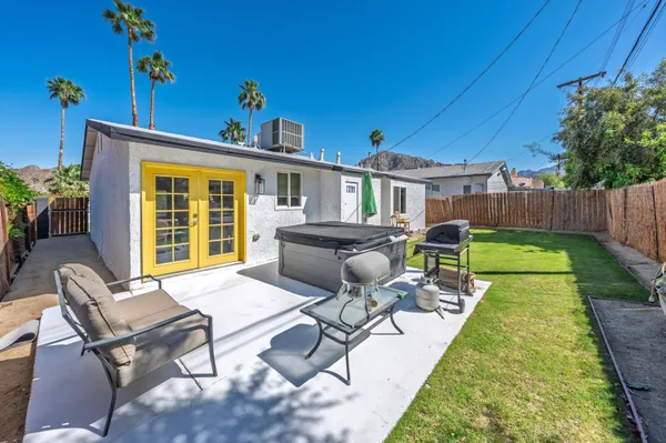 a view of a backyard with furniture potted plants and wooden fence