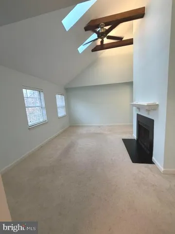 a view of an empty room with a fireplace and a window