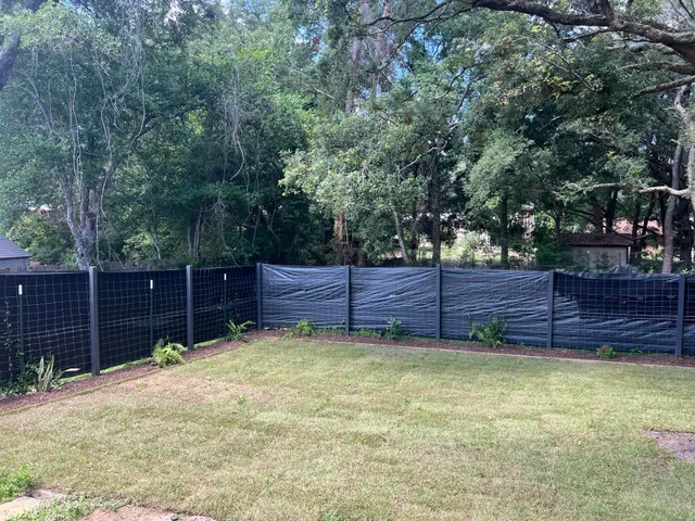 a view of a backyard with wooden fence