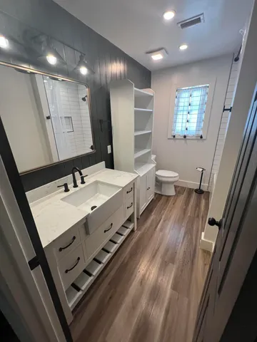 a spacious bathroom with double vanity sink a mirror and a shower