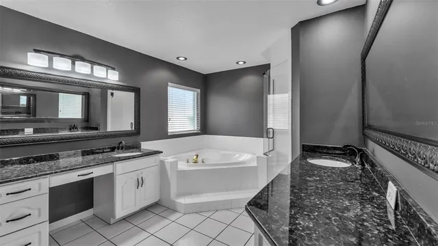 a bathroom with a granite countertop sink a mirror and shower