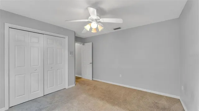 a view of an empty room with a chandelier fan