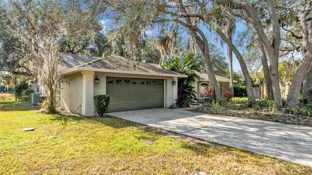 a view of a house with a yard and large tree