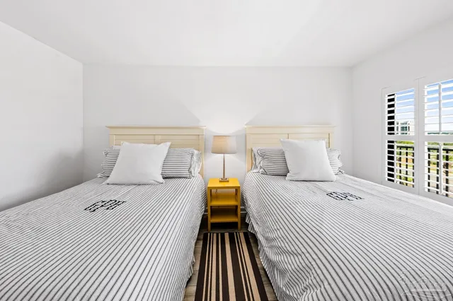 a living room with furniture a flat screen tv and a floor to ceiling window