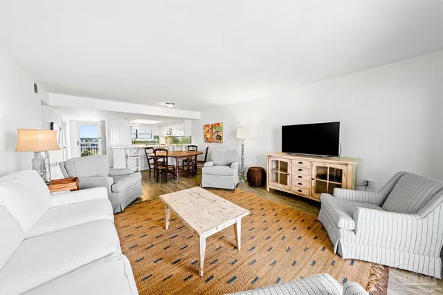 a living room with furniture and view of kitchen