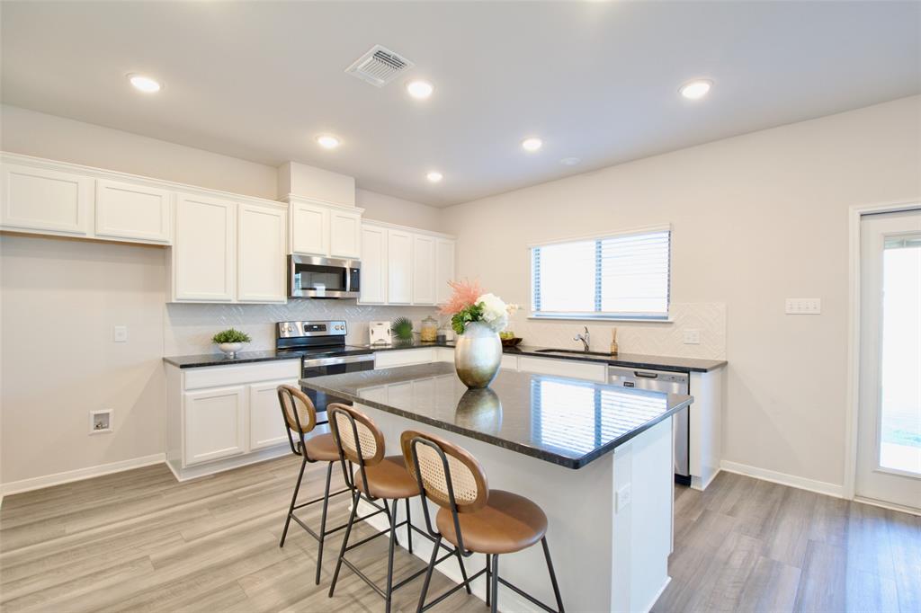 11229 Solar Street Lorena, TX 76655 - Photo 11 of 34 Kitchen featuring decorative backsplash, light wood finished floors, a kitchen island, appliances with stainless steel finishes, and recessed lighting