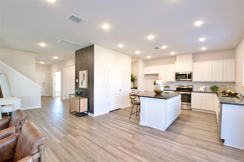 11229 Solar Street Lorena, TX 76655 - Photo 13 of 34 Kitchen featuring a breakfast bar, a kitchen island, backsplash, stainless steel appliances, and white cabinetry