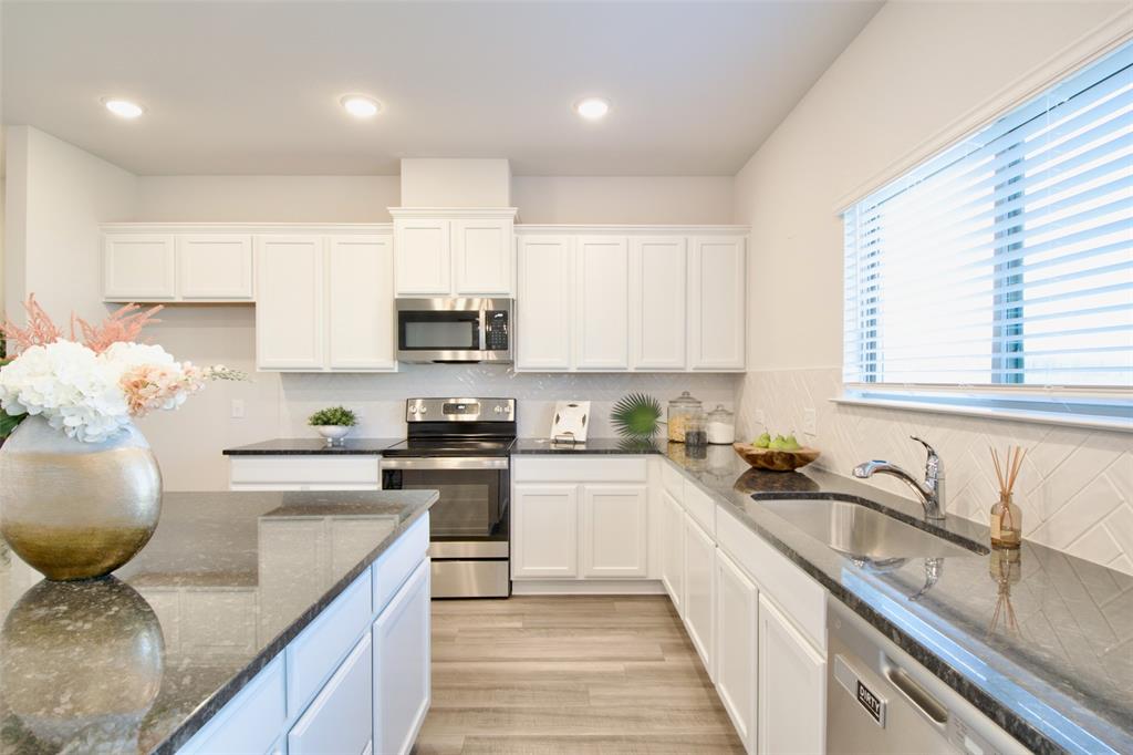 11229 Solar Street Lorena, TX 76655 - Photo 10 of 34 Kitchen featuring appliances with stainless steel finishes, decorative backsplash, dark stone counters, white cabinetry, and recessed lighting