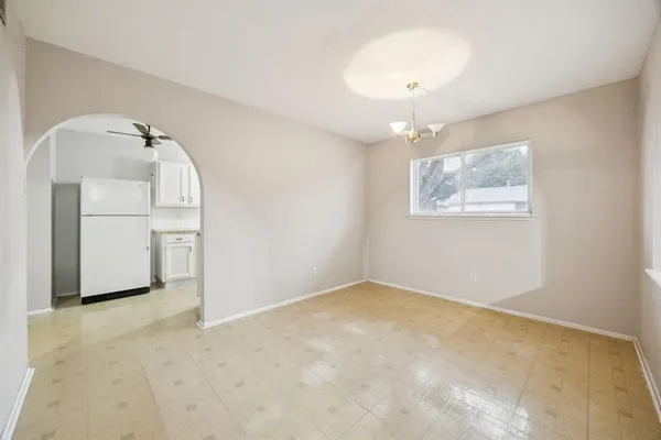 an empty room with windows and cabinet