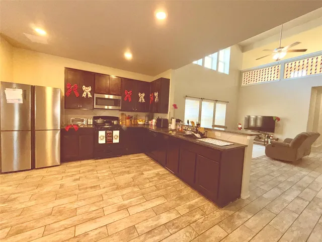 a kitchen with stainless steel appliances granite countertop a refrigerator and a sink