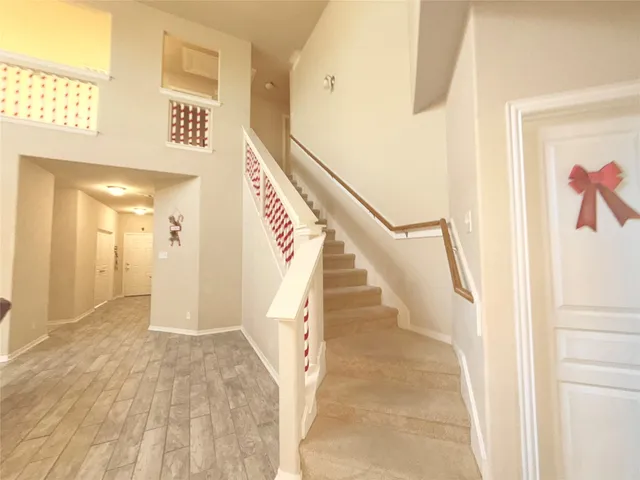 a view of a hallway with wooden floor and staircase