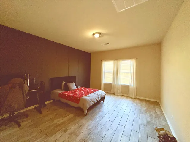 a bedroom with a bed and wooden floor