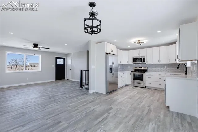 a open kitchen with white cabinets and stainless steel appliances