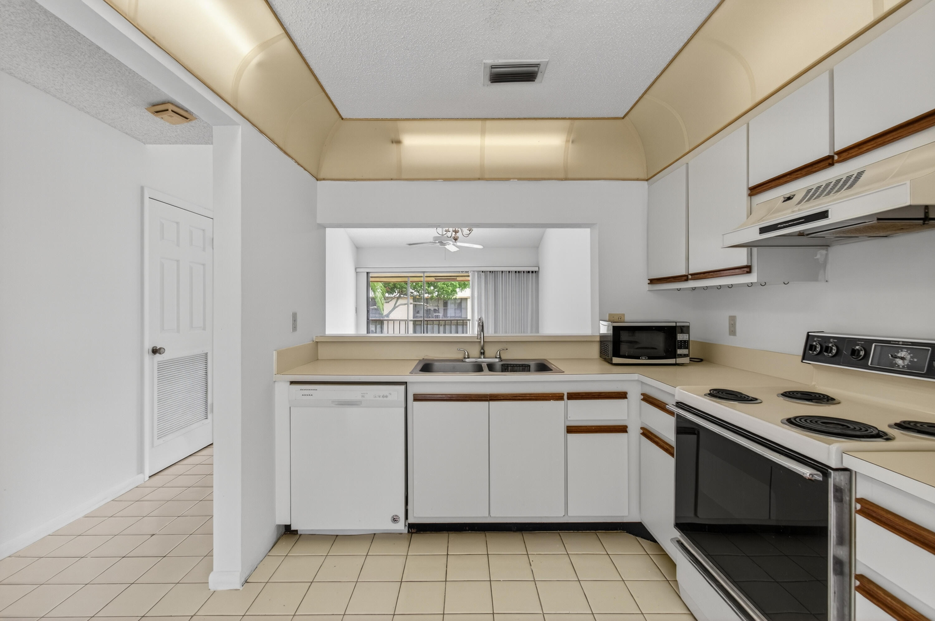 3939 Northeast 5th Avenue, Unit C203 Boca Raton, FL 33431 - Photo 3 of 30 a kitchen with a stove sink and cabinets