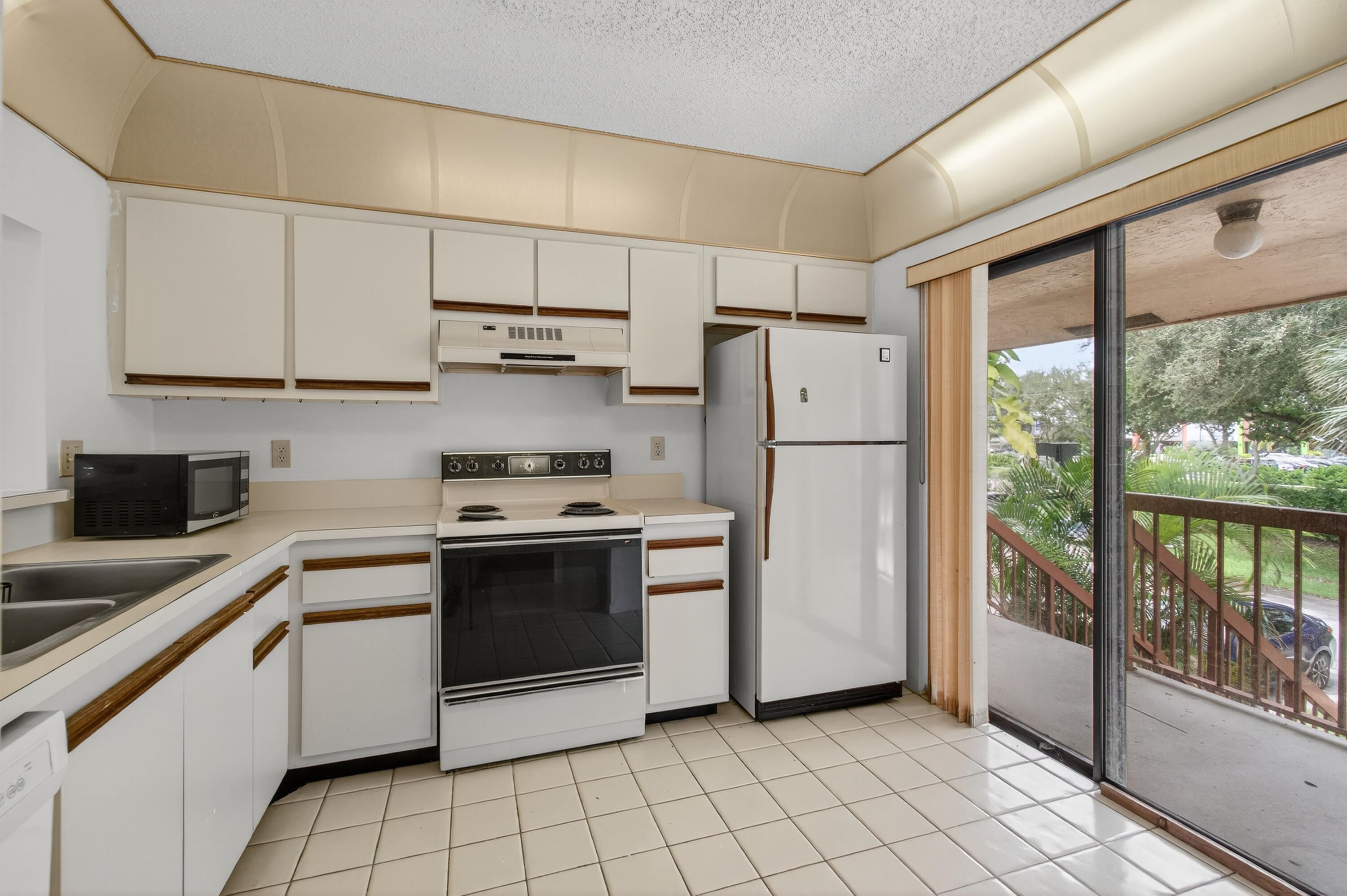 3939 Northeast 5th Avenue, Unit C203 Boca Raton, FL 33431 - Photo 4 of 30 a kitchen with stainless steel appliances a refrigerator sink and cabinets