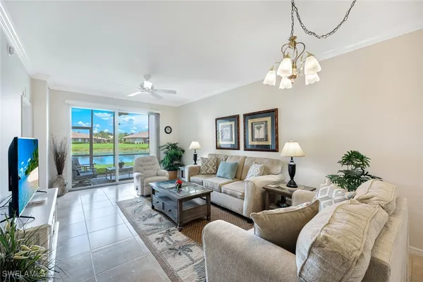 a living room with furniture chandelier and a large window