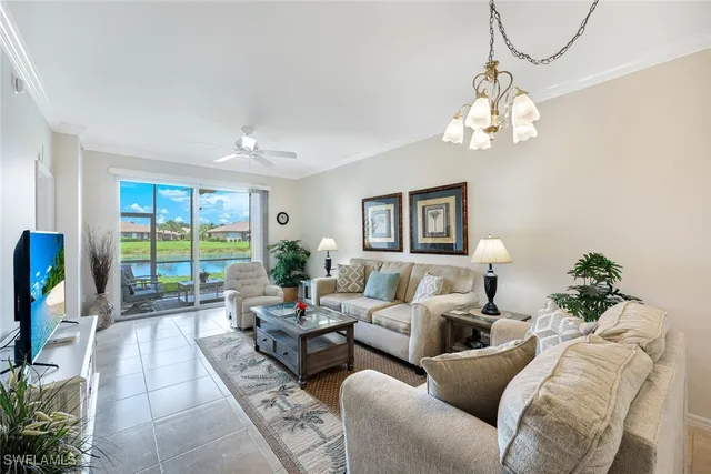 a living room with furniture chandelier and a large window