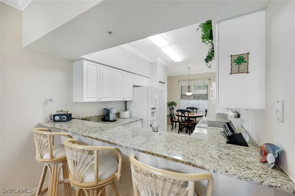 a kitchen with granite countertop kitchen island stainless steel appliances a sink counter space and a window