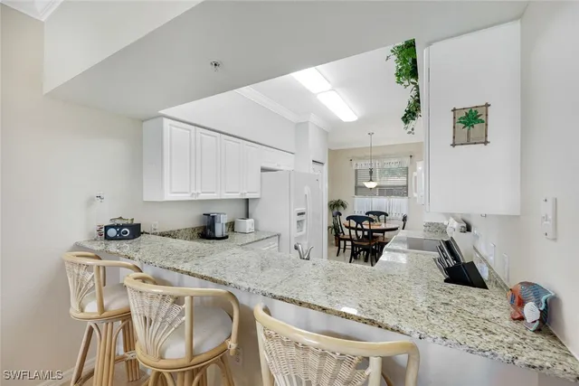 a kitchen with granite countertop kitchen island stainless steel appliances a sink counter space and a window