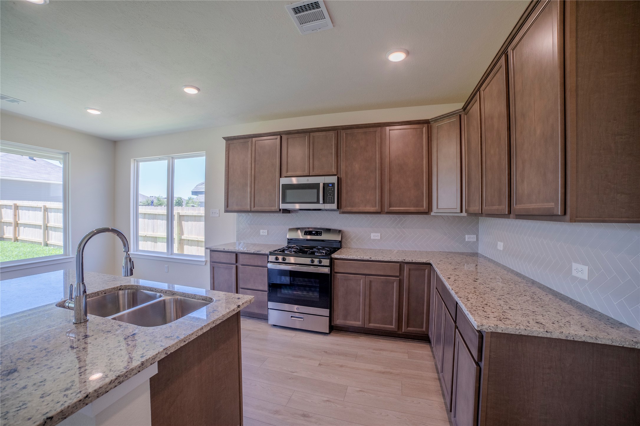 1402 Lk Rdg Drive Brenham, TX 77833 - Photo 21 of 35 a kitchen with granite countertop stainless steel appliances a sink a stove a counter space and cabinets