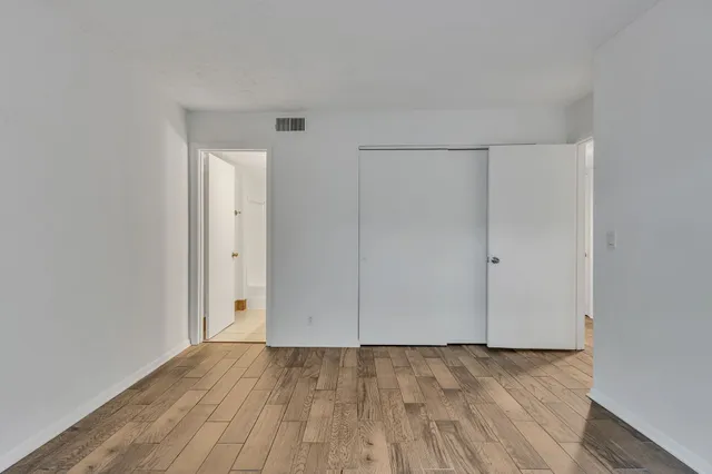 a view of an empty room with wooden floor