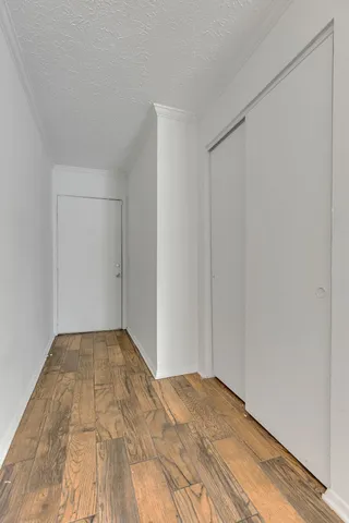 an empty room with wooden floor fireplace and windows