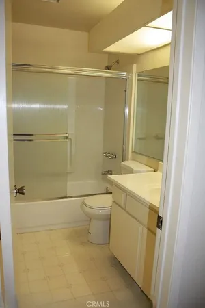 a bathroom with a granite countertop shower a toilet and a sink