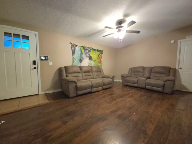 a living room with furniture and a ceiling fan