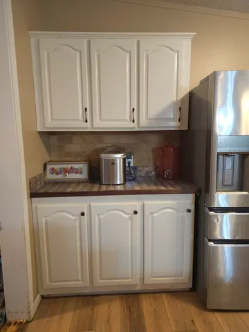 a kitchen with stainless steel appliances granite countertop a refrigerator stove and white cabinets