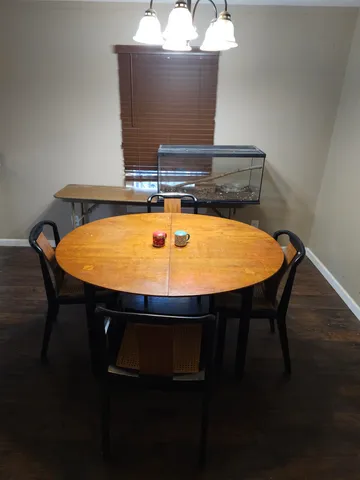 a room with a table chairs and wooden floor