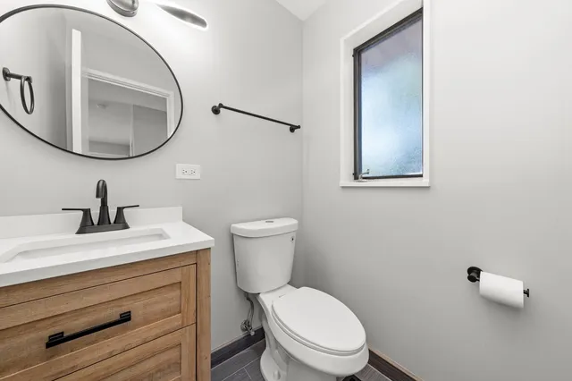 a bathroom with a toilet sink and mirror