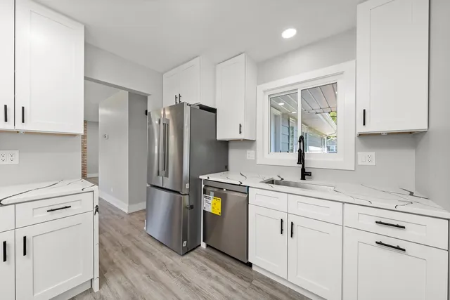 a kitchen with a refrigerator sink and cabinets