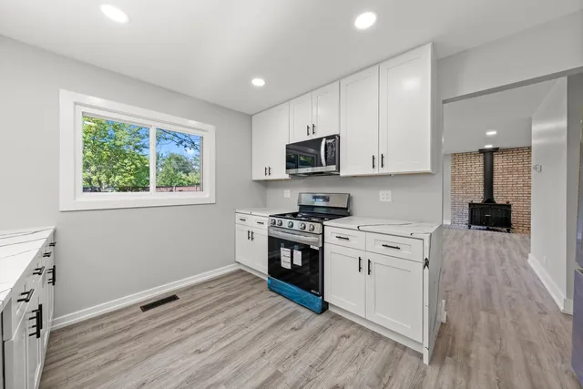 a kitchen with a stove a sink and a microwave