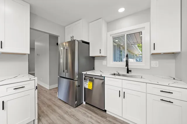 a kitchen with stainless steel appliances granite countertop a refrigerator a stove a sink and a microwave