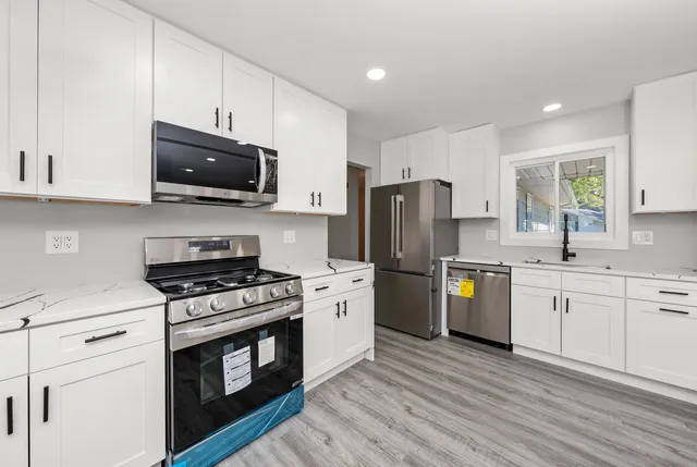 a kitchen with stainless steel appliances a stove a sink and a microwave