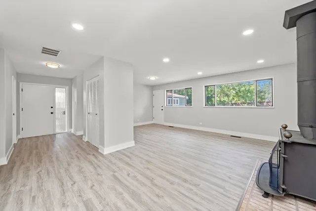 a view of a big room with wooden floor and windows