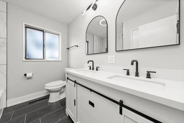 a bathroom with a granite countertop sink mirror and toilet