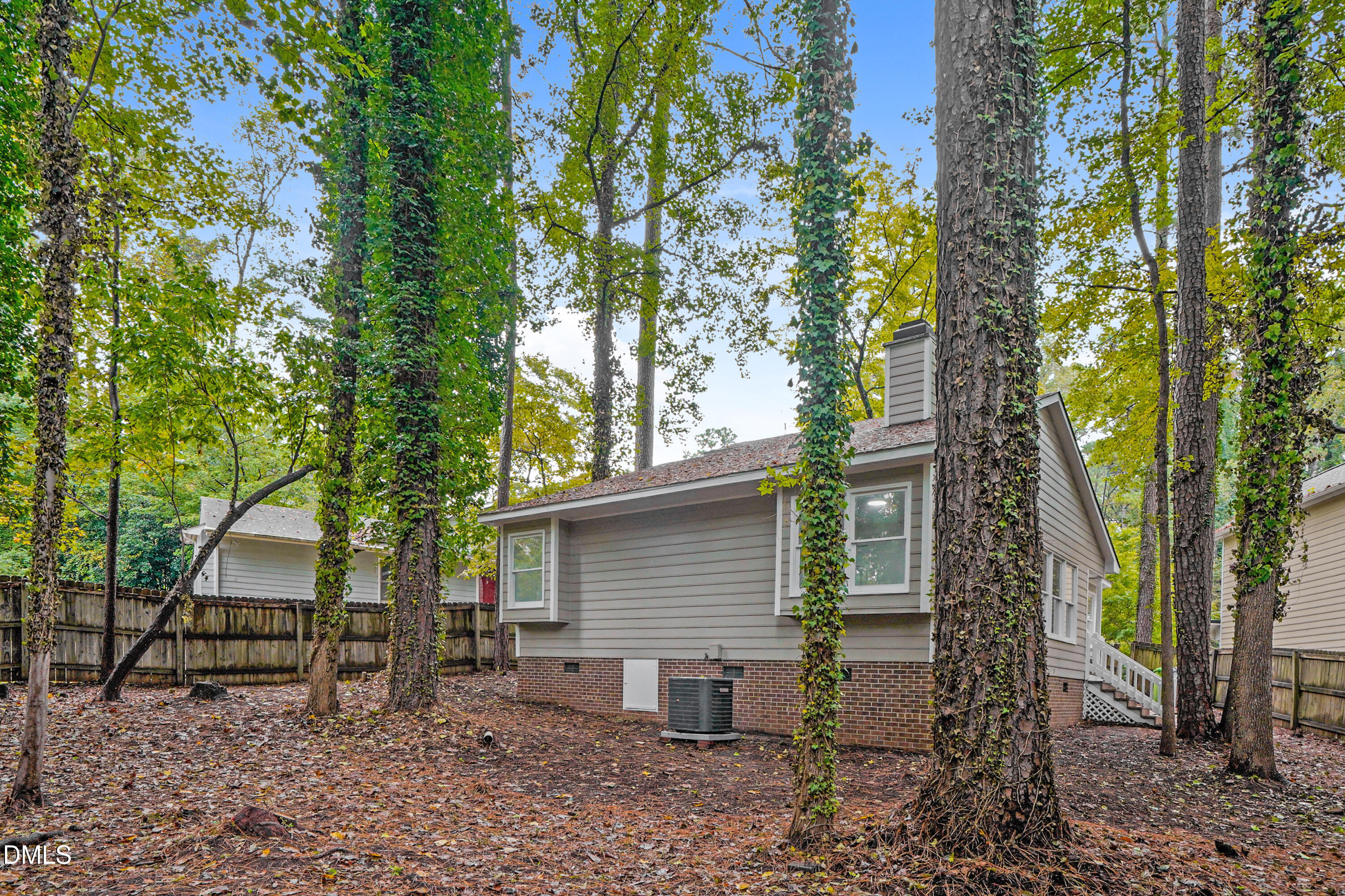 105 Stonelake Court Raleigh, NC 27610 - Photo 15 of 15 a view of a backyard with large trees and wooden fence