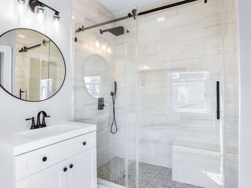 58 Telegraph Street, Unit 2 Boston, MA 02127 - Photo 10 of 17 a bathroom with a sink a mirror a glass door and shower