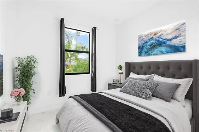 a bedroom with a bed and a painting on the wall