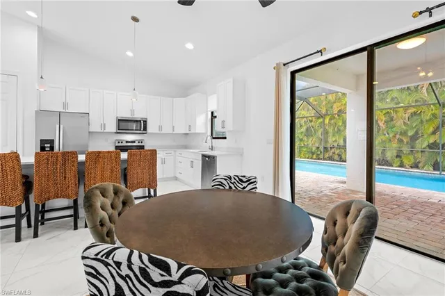a kitchen with kitchen island a stove a table and a refrigerator