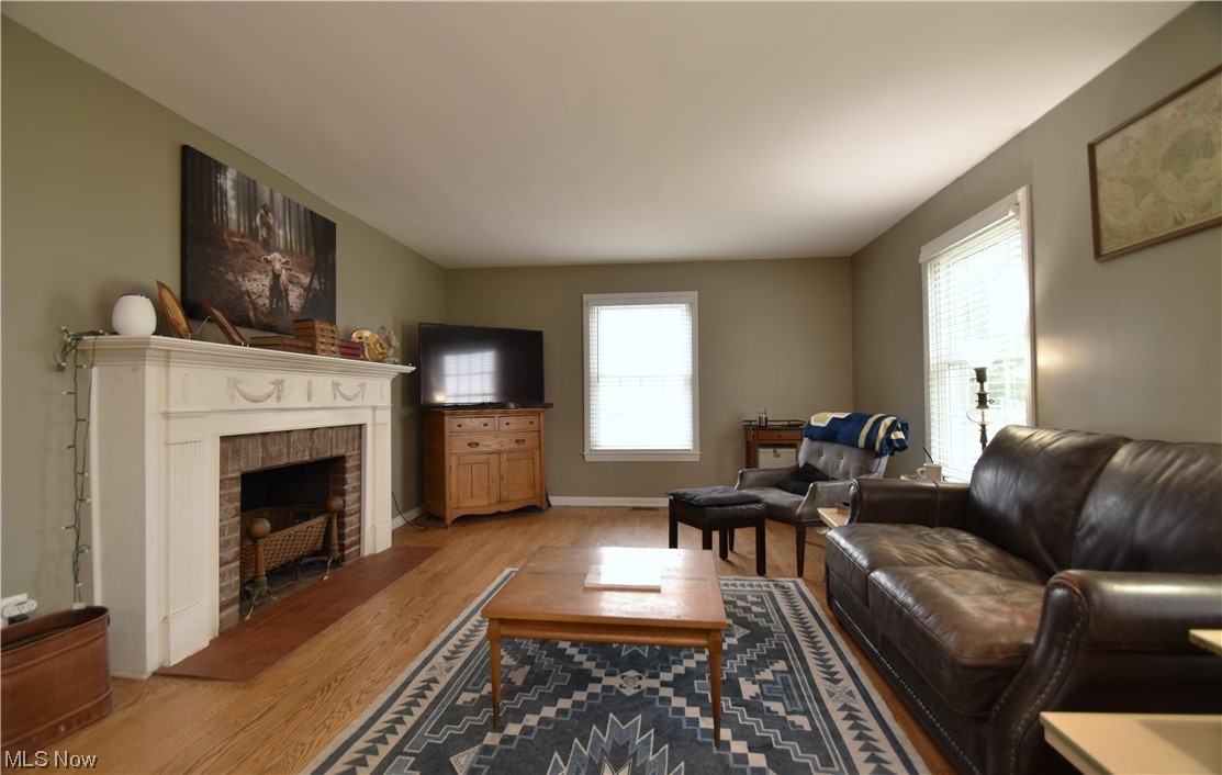 149 North Medina Line Road Akron, OH 44333 - Photo 5 of 36 Living room featuring a brick fireplace and harwood floors.