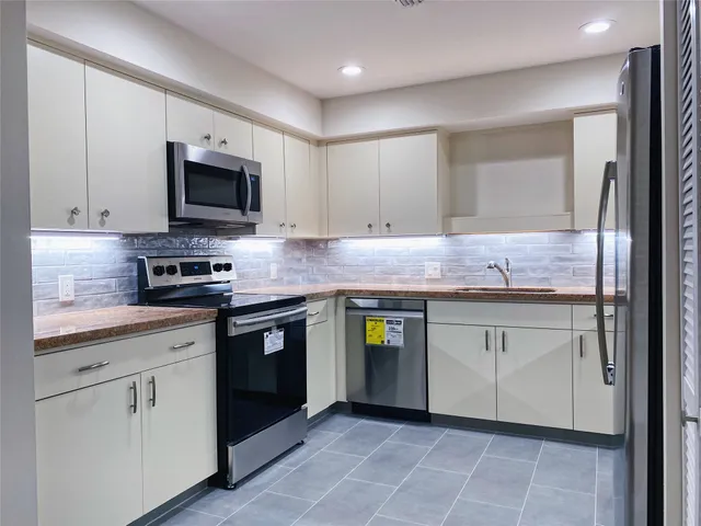 a kitchen with granite countertop cabinets stainless steel appliances and a counter space